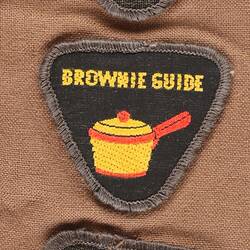 Three Brownie badges on brown cloth