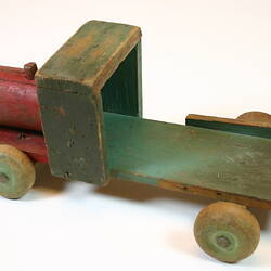 Multi-coloured wooden toy truck, left view.