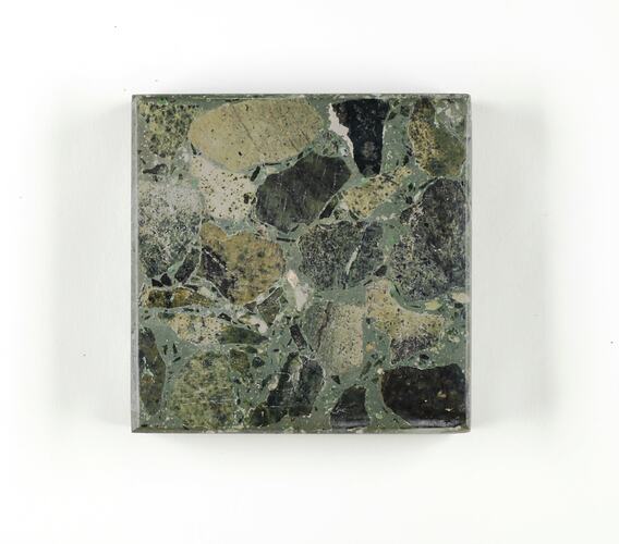 Square terrazzo with green base and coloured aggregate in shades of mottled green and black.