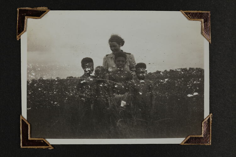 Woman standing behind four boys.
