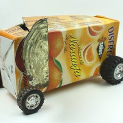 Toy tanker made from orange juice carton, side view.