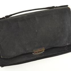 Closed leather purse with handle.