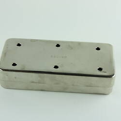 Metal rectangular box with six holes around and word RECORD imprinted in centre.