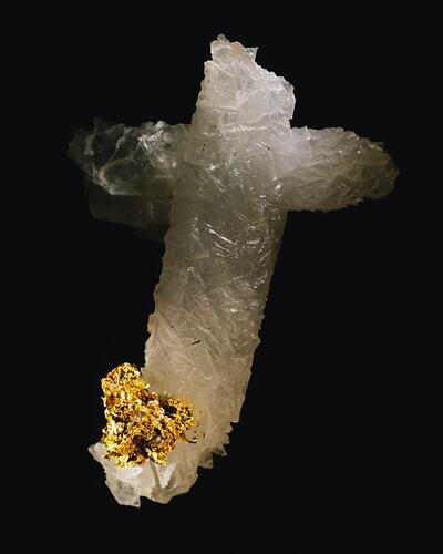 Godl crystals on a cross-shaped piece of white quartz.