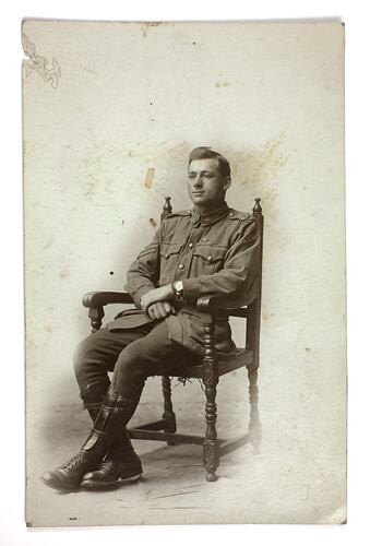 Man in uniform seated in chair.