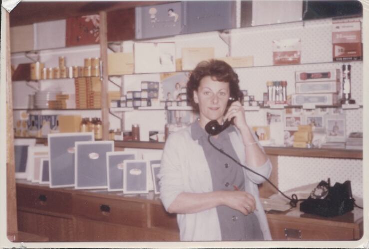 Woman on phone in photosupply shop.