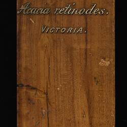 Timber sample with painted gold lettering.