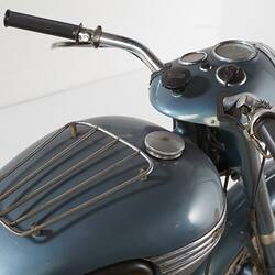 Blue metallic motor cycle. Tank, handle bars and dash detail, rear right view.