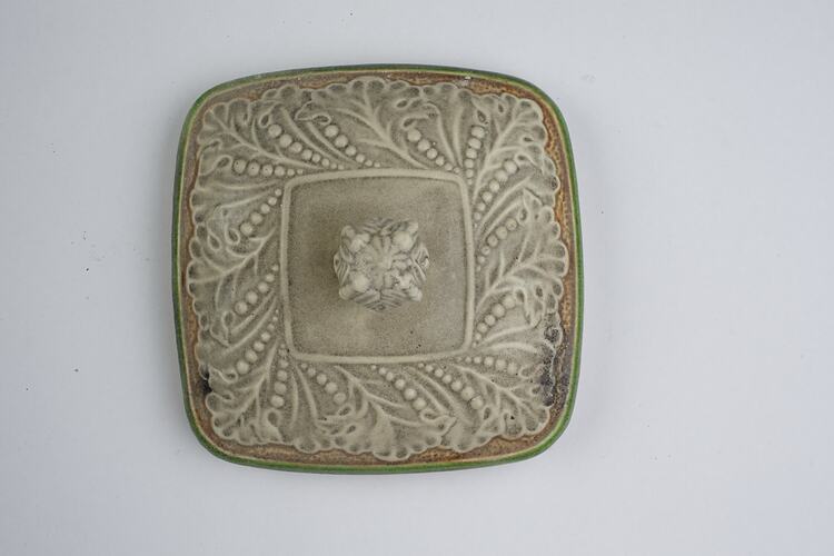 Fire affected cream ceramic lid.