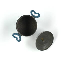 Inside of tiny aluminium pot, lid detached.