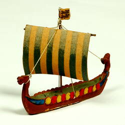 Three quarter view of ship with dragon head and shields.