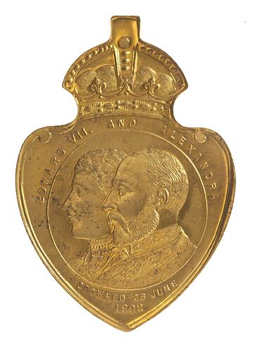Heart shaped medal with crown atop. Features conjoined busts of woman and man facing left. Text around.