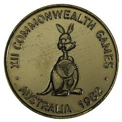 Round gilt medal with kangaroo caricature standing facing 3/4 right holding Brisbane Commonwealth Games logo.