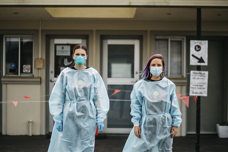 Staff Members Stand in Surgical Gowns in Carpark at First Peoples Health and Wellbeing Clinic, Thomastown, Wurundjeri Woi Wurrung Country, Victoria, 25 Mar 2021