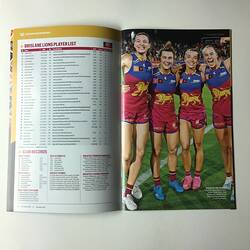 Open football record with text on left page and four female footballers on right page.