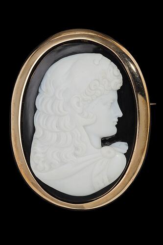 Oval brooch, white cameo of female facing right with black background set in gold border.