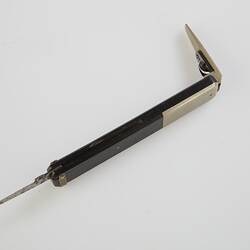 Quill pen cutter with black handle. Engraved silver metal quill cutter open at one end, open knife at other.