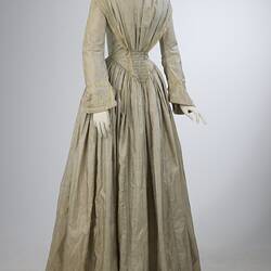 Pale grey striped silk dress with long sleeves and long skirt.