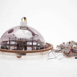 Profile of clear dome containing computer components. Cable attached.