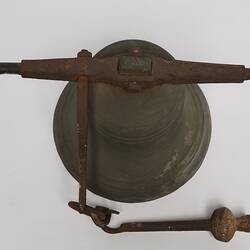 Metal bell, with a metal ringer for striking the bell. Top vew.