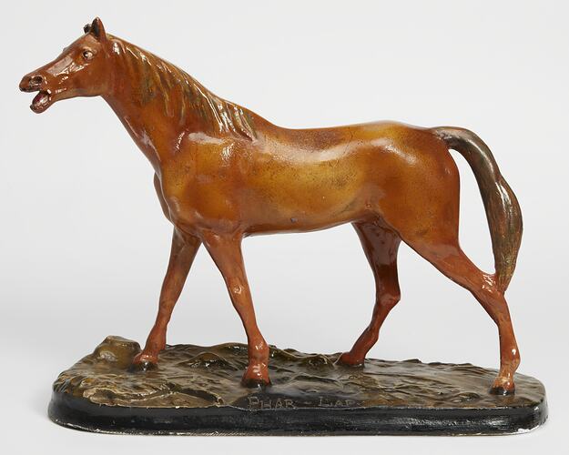 Plaster moulded, hand painted brown horse with a black base. Left profile.