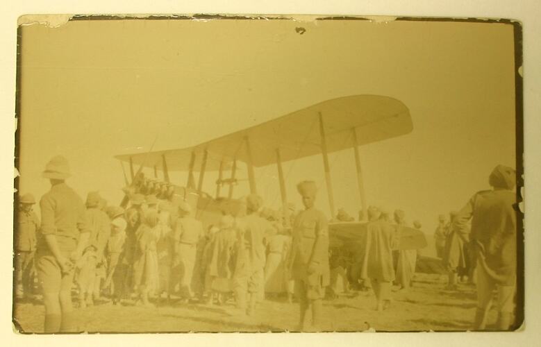 Landed aeroplane surrounded by people.