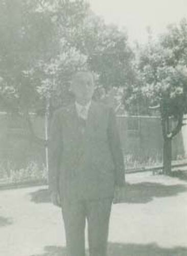 Portrait of a man standing in a garden.