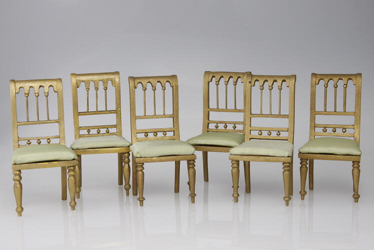 Six wooden upright chairs.