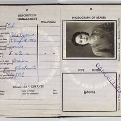 Open passport with white pages, black printing and handwriting. Photo of woman. Stamped.