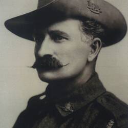 Photograph of a man with a moustache wearing a hat.
