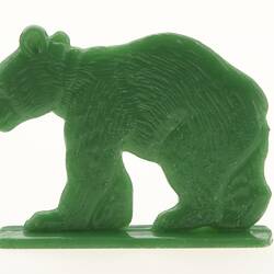Plastic green bear ornament in profile.