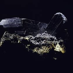 Black crystal blocks protruding from a rock.