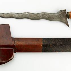 Metal dagger with undulating blade and wooden handle. Wooden sheath has painted foliage pattern.
