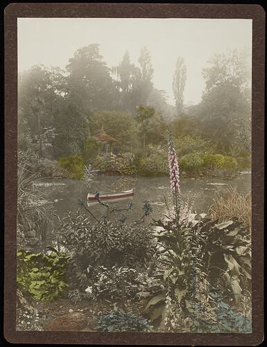 River with red canoe amongst lush garden foliage.