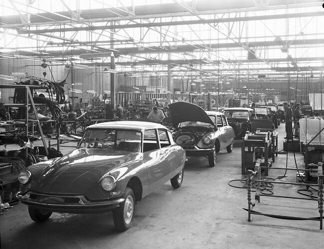 Monochrome photograph of a vehicle manufacturing plant.