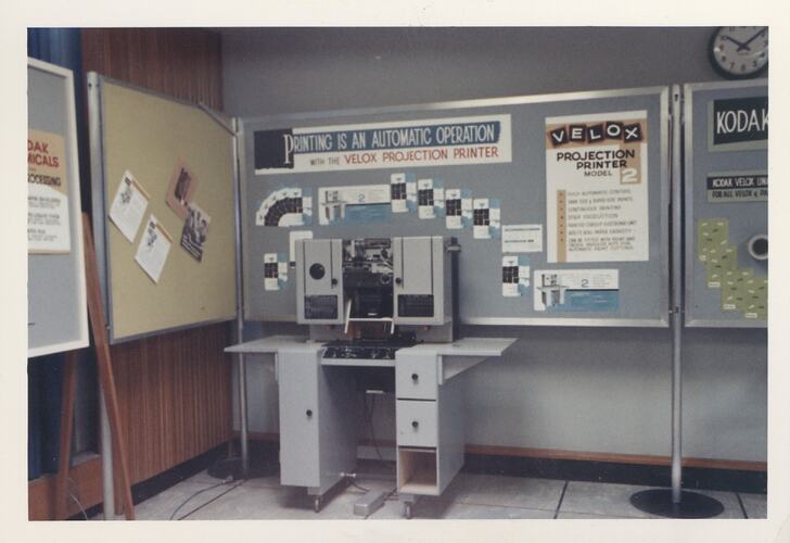 Large machine in front of display panels.