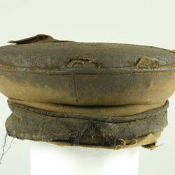 Front view of old battered nightsoil collector's khaki flat top cap