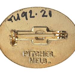 Back of oval metal pin badge.