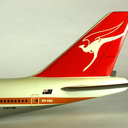 White model plane with red trim, detail of back and tail section. White kangaroo logo on tail. Detail of cockp