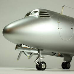 Silver model aeroplane. Front of plane with cockpit detail.