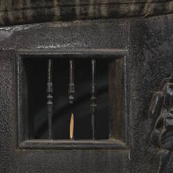 Black wooden hearse, detail of decorative woodwork. Vent with three turned bars.