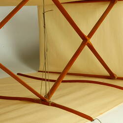 Box kite with two square sections made of cream fabric with wood and metal frame. Frame detail.