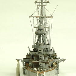 Naval ship with two masts, front view.