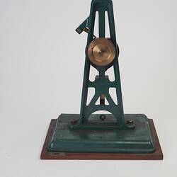 Metal model with green painted frame with metal heart shape and upright rod.