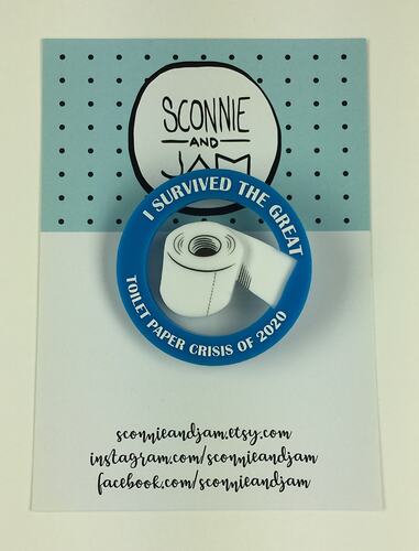 Badge featuring white toilet paper roll and slogan