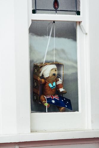 Injured teddy placed in window.