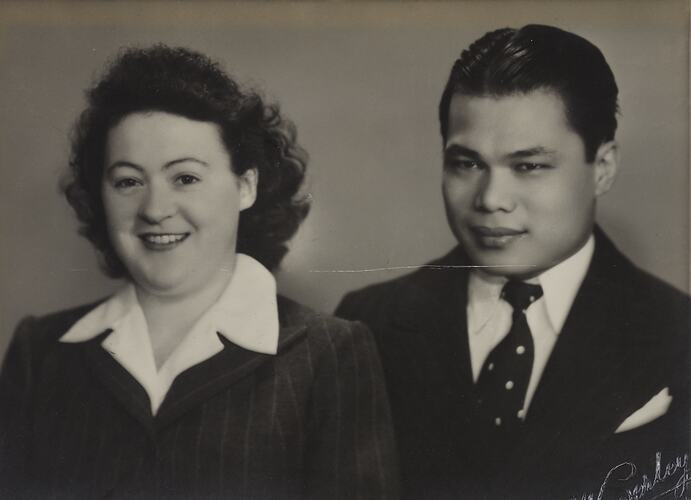 Woman and man smile and pose. She wears a white shirt, dark jacket. He wears shirt, tie and jacket.