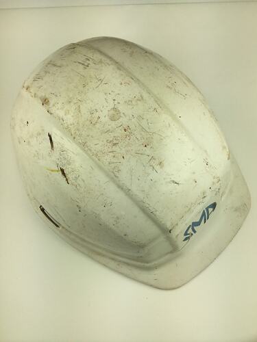 Used, scuffed white safety helmet. Top view.