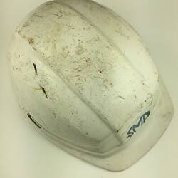 Used, scuffed white safety helmet. Top view.