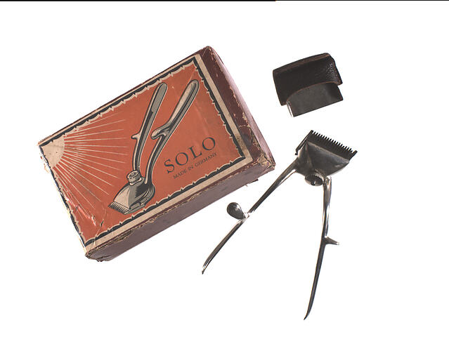 Cardboard box with hair clippers adjacent.